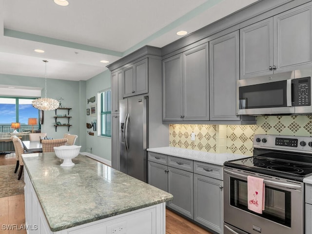 930 Cape Marco Dr Unit 806, Marco Island, FL 34145 - kitchen with hanging light fixtures, decorative backsplash, light stone countertops, and appliances with stainless steel finishes