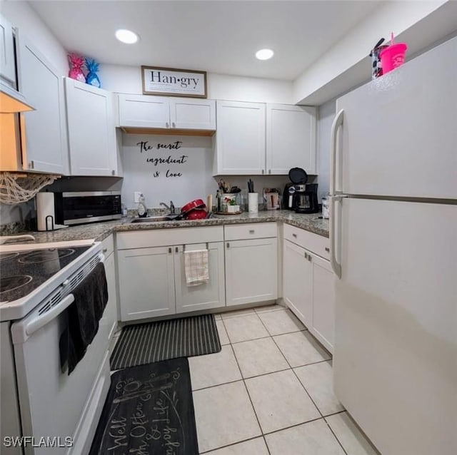 kitchen featuring light tile patterned flooring, white appliances, sink, and white cabinets