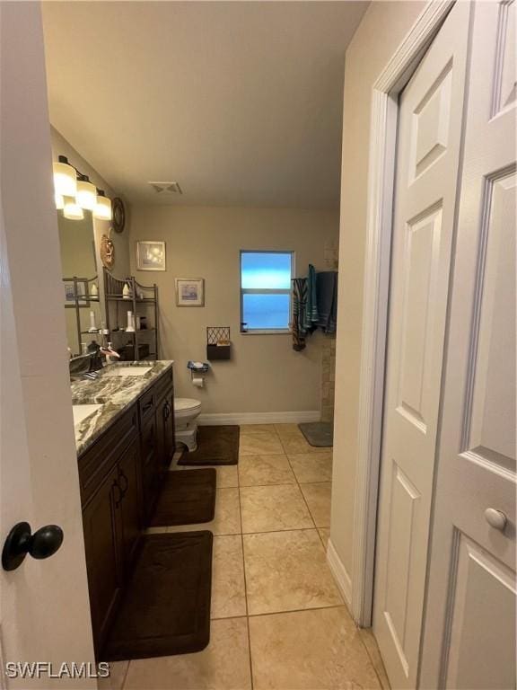 bathroom with tile patterned flooring, vanity, and toilet