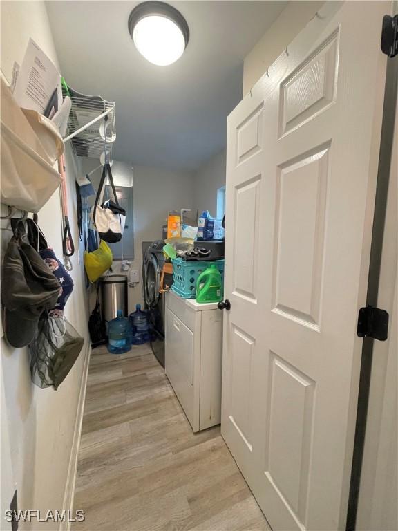 laundry room featuring washer and dryer and light hardwood / wood-style flooring