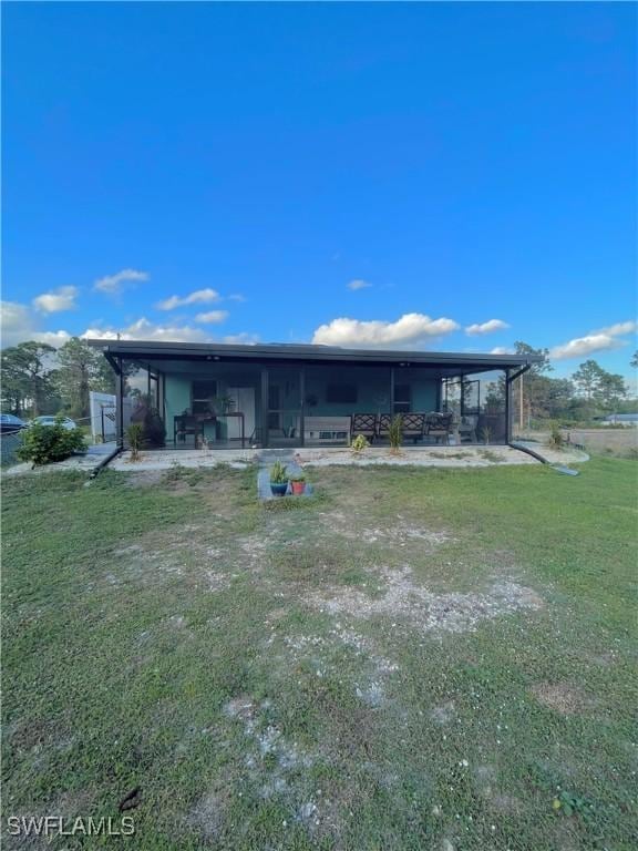 back of house with a patio area and a lawn