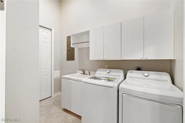 clothes washing area with cabinet space, electric panel, washer and dryer, a sink, and light tile patterned flooring