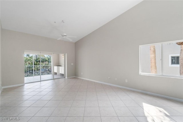 spare room with light tile patterned floors, baseboards, high vaulted ceiling, and a ceiling fan