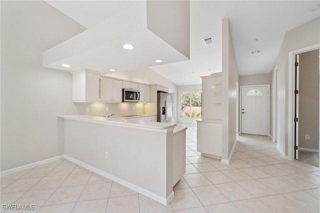 kitchen with stainless steel appliances, visible vents, light countertops, white cabinets, and a peninsula