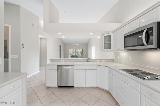 kitchen featuring appliances with stainless steel finishes, white cabinets, light countertops, and a sink