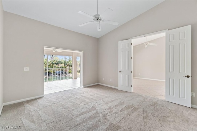 empty room with light tile patterned floors, light carpet, vaulted ceiling, ceiling fan, and baseboards