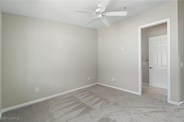 empty room with light carpet, ceiling fan, and baseboards