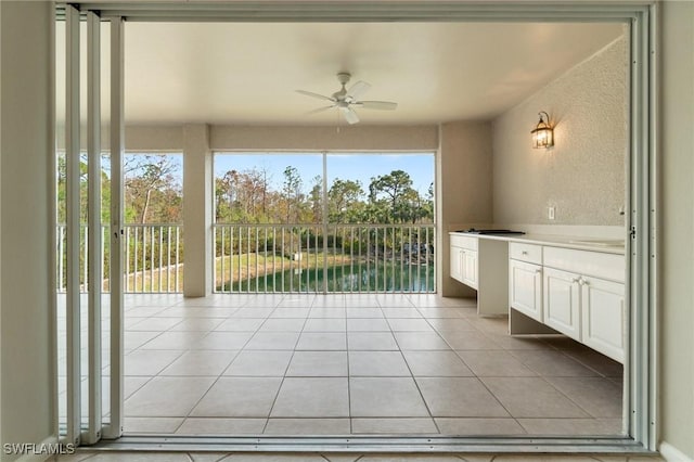 interior space with a water view and a ceiling fan