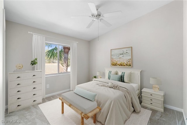 bedroom with lofted ceiling, baseboards, a ceiling fan, and light colored carpet