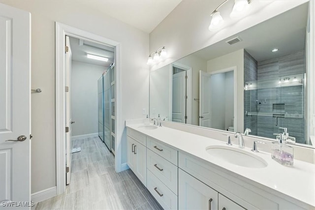 bathroom with walk in shower, vanity, and toilet