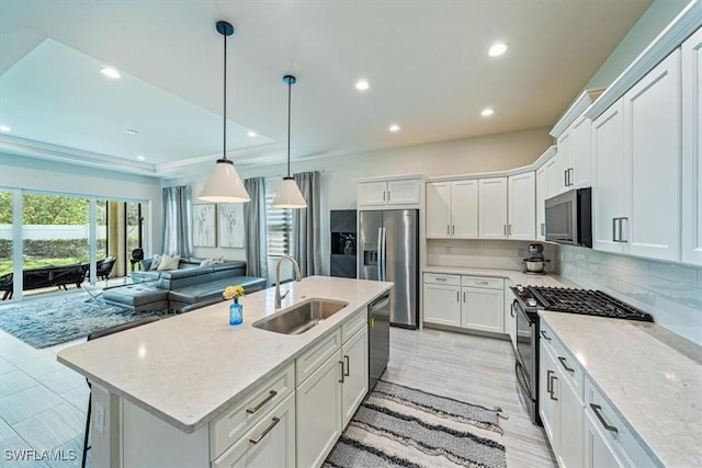 kitchen featuring white cabinetry, appliances with stainless steel finishes, sink, and light stone counters