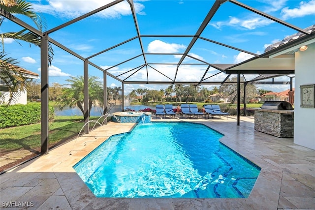 view of swimming pool with glass enclosure, a patio, exterior kitchen, a pool with connected hot tub, and a water view