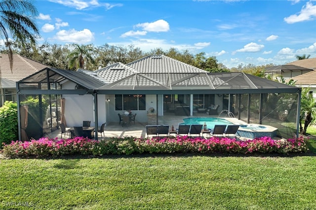 rear view of house featuring a tile roof, a patio area, glass enclosure, and a yard