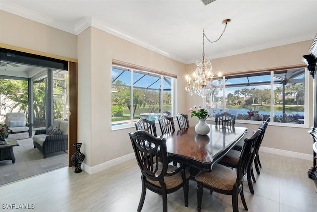 dining space featuring ornamental molding, baseboards, a water view, and a chandelier