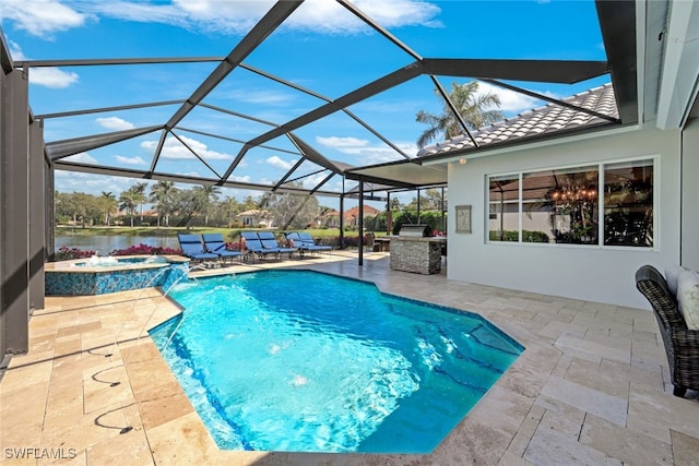 view of swimming pool with a pool with connected hot tub, a water view, a patio area, glass enclosure, and exterior kitchen