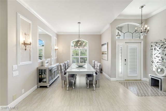 dining room featuring a chandelier, ornamental molding, and baseboards