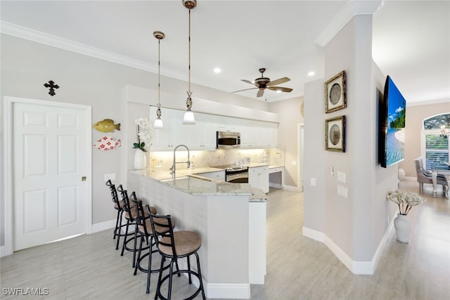 kitchen with hanging light fixtures, appliances with stainless steel finishes, white cabinetry, a peninsula, and a kitchen bar