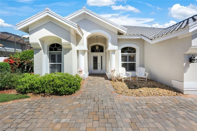 property entrance with a tiled roof and stucco siding