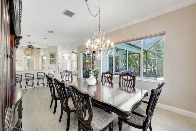 dining space with baseboards, visible vents, ornamental molding, and ceiling fan with notable chandelier