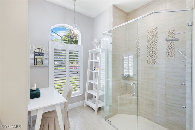 full bathroom with a chandelier, a stall shower, and baseboards