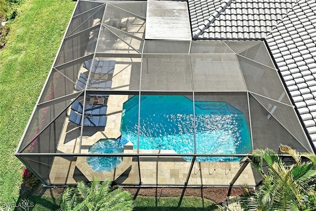 pool with glass enclosure and a patio