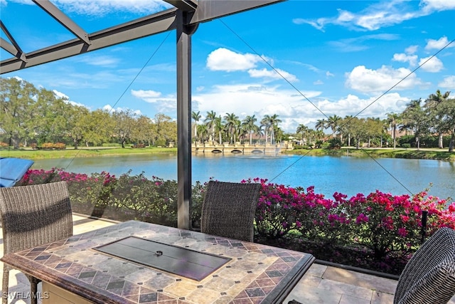 view of patio / terrace featuring a water view and a lanai