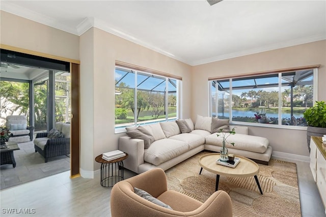 living area featuring baseboards, a water view, and ornamental molding