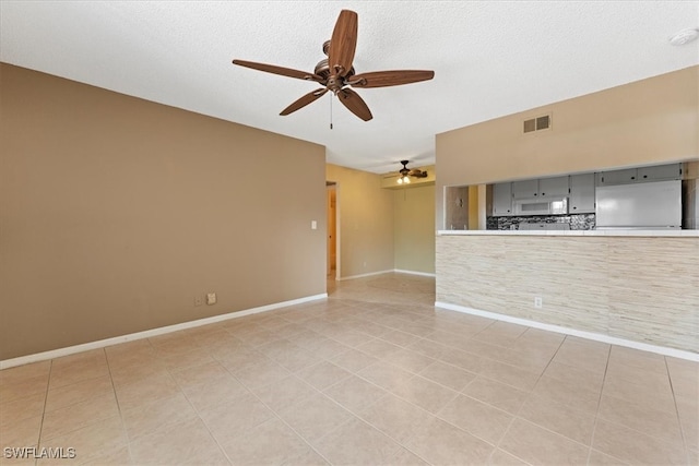 4345 27th Ct SW Unit 204, Naples, FL 34116 - unfurnished living room featuring ceiling fan, light tile patterned flooring, baseboards, and a textured ceiling
