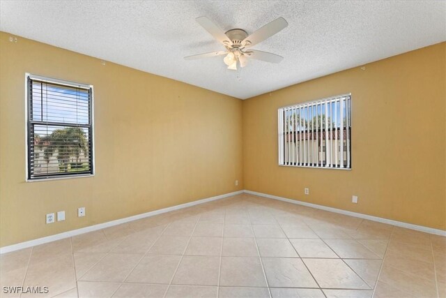 4345 27th Ct SW Unit 204, Naples, FL 34116 - empty room with a ceiling fan, a textured ceiling, light tile patterned floors, and baseboards