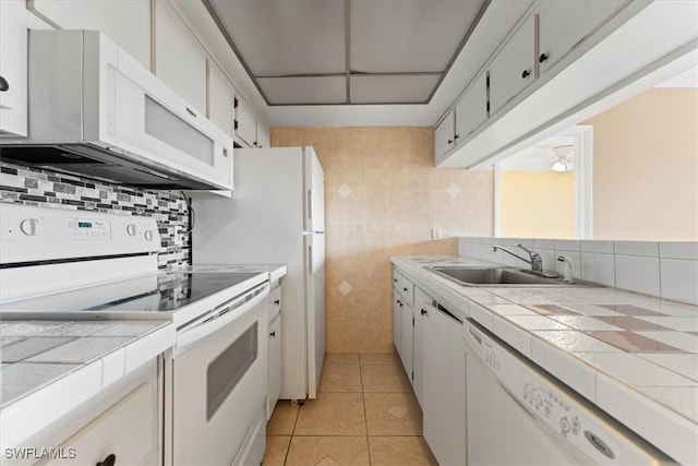 4345 27th Ct SW Unit 204, Naples, FL 34116 - kitchen featuring white appliances, a sink, tile counters, and white cabinets