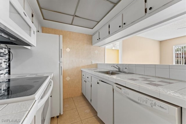 4345 27th Ct SW Unit 204, Naples, FL 34116 - kitchen with white appliances, a sink, tile walls, light tile patterned floors, and tasteful backsplash