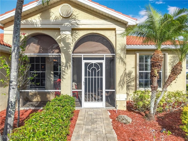 property entrance with a tiled roof and stucco siding