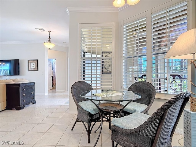 dining room featuring light tile patterned floors, baseboards, visible vents, and crown molding