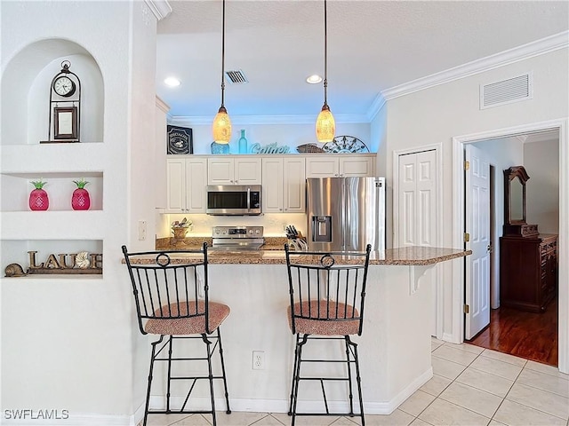 kitchen with visible vents, appliances with stainless steel finishes, and a breakfast bar