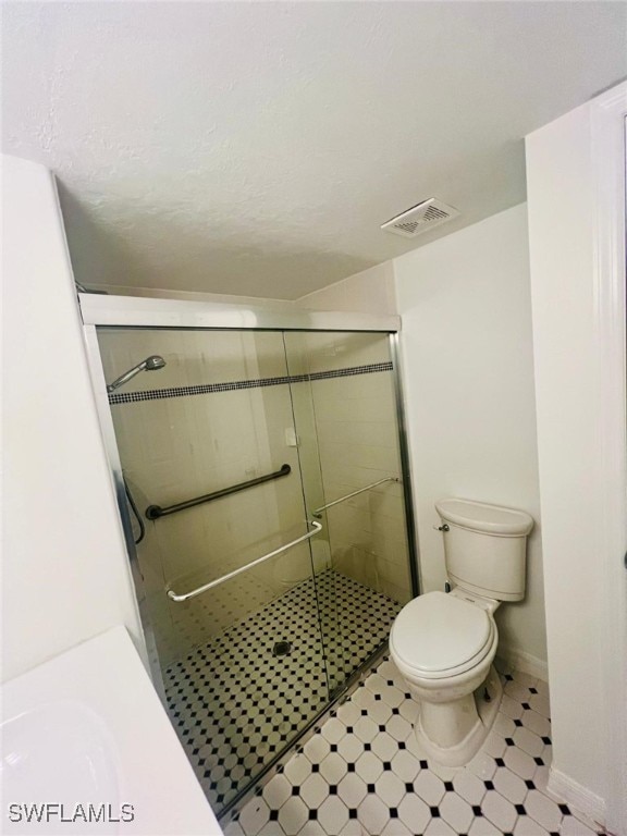 bathroom featuring toilet and walk in shower