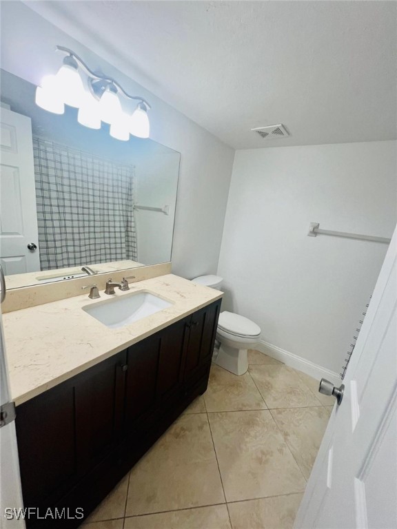 bathroom with vanity, toilet, and tile patterned flooring