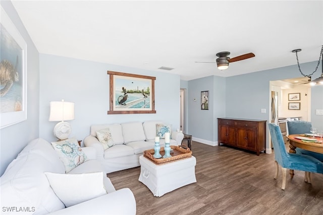 living room featuring dark hardwood / wood-style floors and ceiling fan