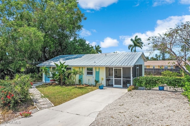 single story home with a front lawn and a sunroom