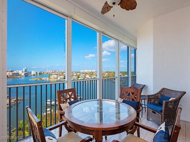 sunroom featuring a water view and ceiling fan