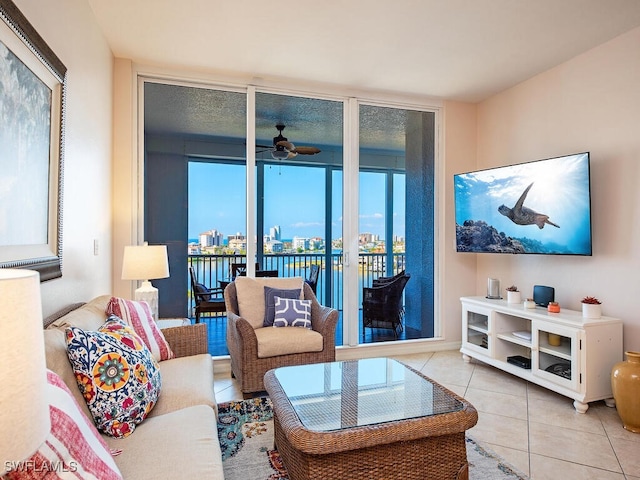 living room featuring light tile patterned flooring, ceiling fan, and expansive windows