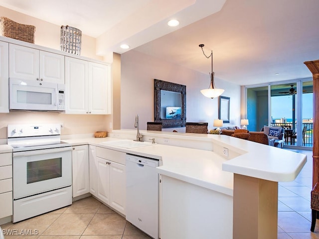 kitchen featuring white appliances, kitchen peninsula, sink, and white cabinets