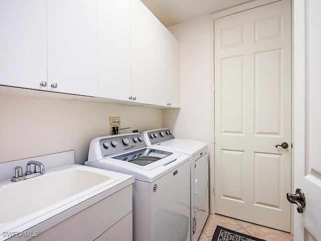 laundry room with sink, light tile patterned floors, cabinets, and washing machine and clothes dryer