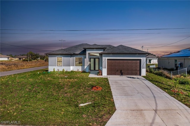 view of front of house featuring a garage and a lawn