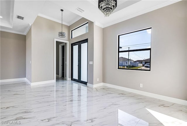 foyer with french doors, ornamental molding, a tray ceiling, and a notable chandelier