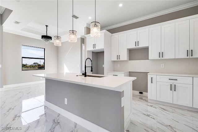 kitchen with white cabinetry, hanging light fixtures, and a center island with sink