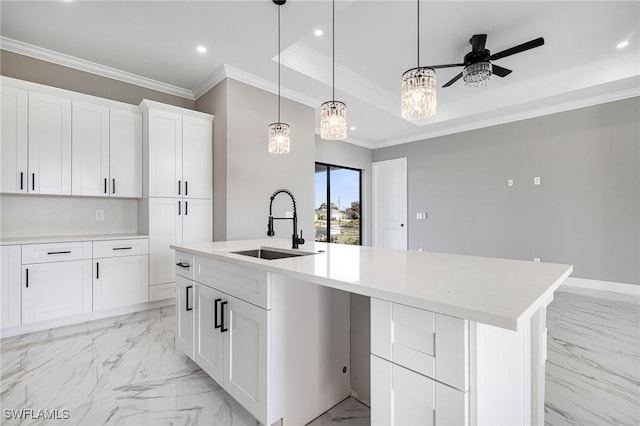 kitchen featuring sink, ceiling fan, a kitchen island with sink, white cabinets, and a raised ceiling