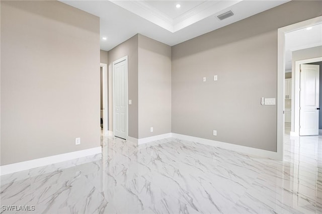 spare room with crown molding and a raised ceiling