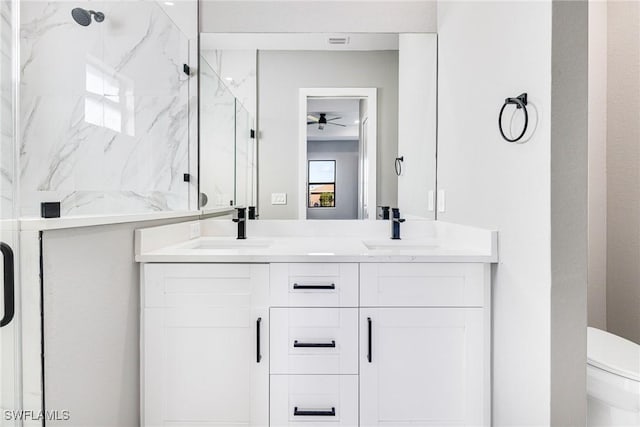 bathroom featuring vanity, toilet, ceiling fan, and walk in shower