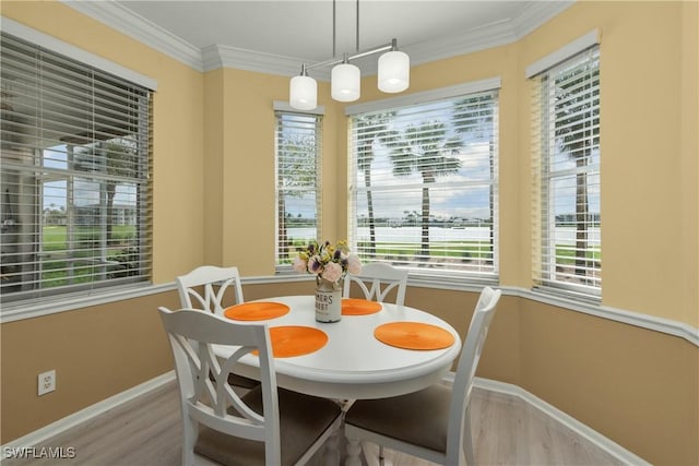 dining area with crown molding and light hardwood / wood-style flooring