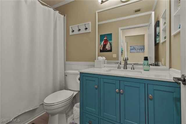 bathroom with vanity, crown molding, and toilet